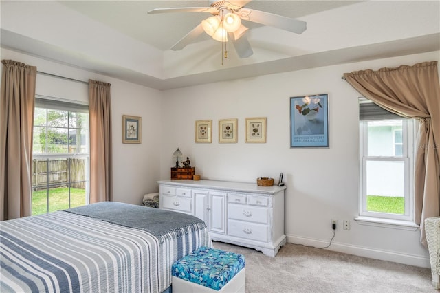 bedroom with multiple windows, light colored carpet, and ceiling fan