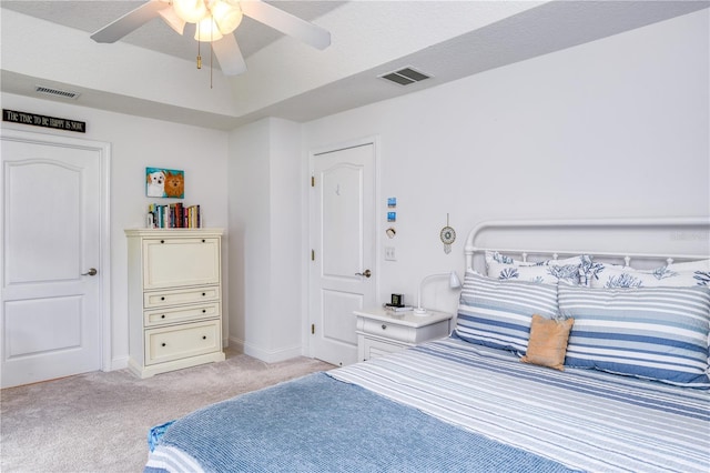 carpeted bedroom featuring ceiling fan and a textured ceiling