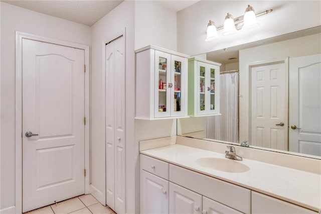 bathroom with vanity, tile patterned flooring, and a textured ceiling