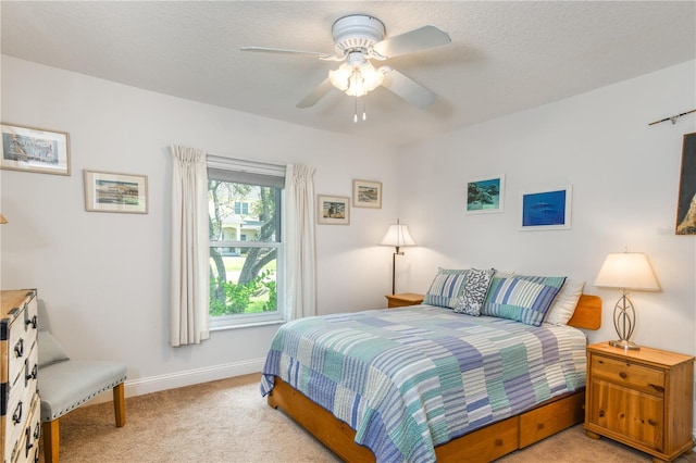 carpeted bedroom with ceiling fan and a textured ceiling