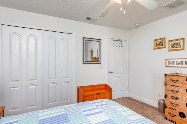 carpeted bedroom featuring ceiling fan, a textured ceiling, and a closet