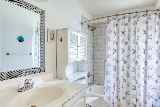 full bathroom with shower / tub combo with curtain, vanity, toilet, and a textured ceiling