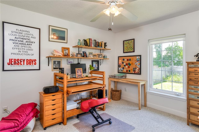 home office featuring light carpet, a textured ceiling, and ceiling fan