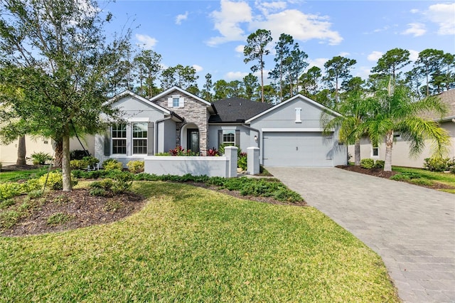 ranch-style house with a front lawn, stucco siding, decorative driveway, stone siding, and an attached garage