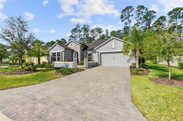 single story home with a garage, decorative driveway, and a front lawn