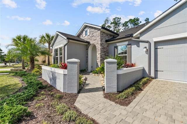 exterior space with stone siding and an attached garage