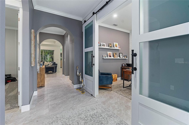 hallway featuring visible vents, arched walkways, baseboards, and crown molding