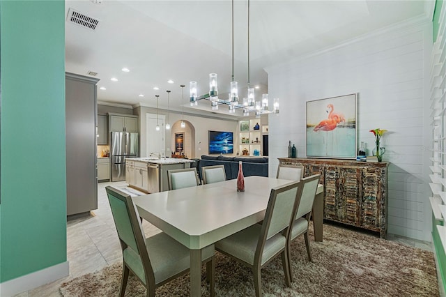 dining area featuring visible vents, an inviting chandelier, recessed lighting, arched walkways, and crown molding