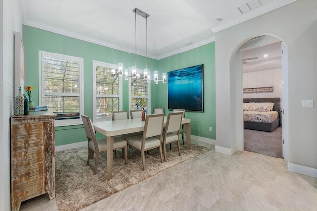 dining room with arched walkways, visible vents, baseboards, and ornamental molding