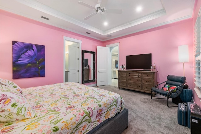 bedroom with a tray ceiling, carpet flooring, visible vents, and ornamental molding