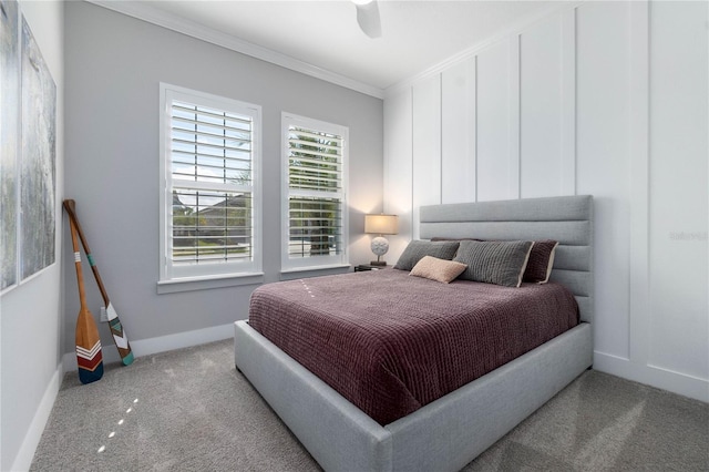 carpeted bedroom with ceiling fan, baseboards, and ornamental molding