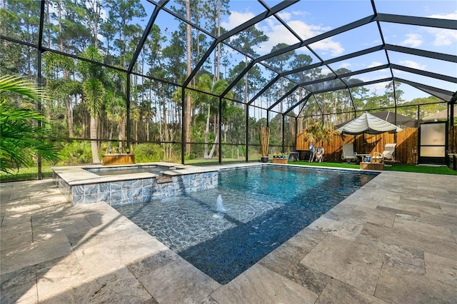 view of pool with a lanai, a pool with connected hot tub, and a patio