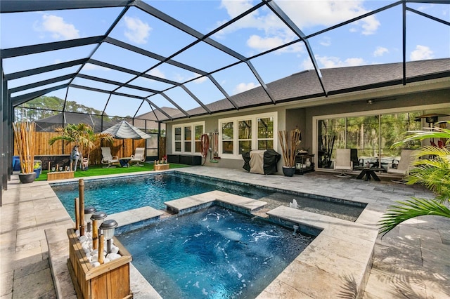 view of swimming pool featuring grilling area, a pool with connected hot tub, fence, glass enclosure, and a patio area