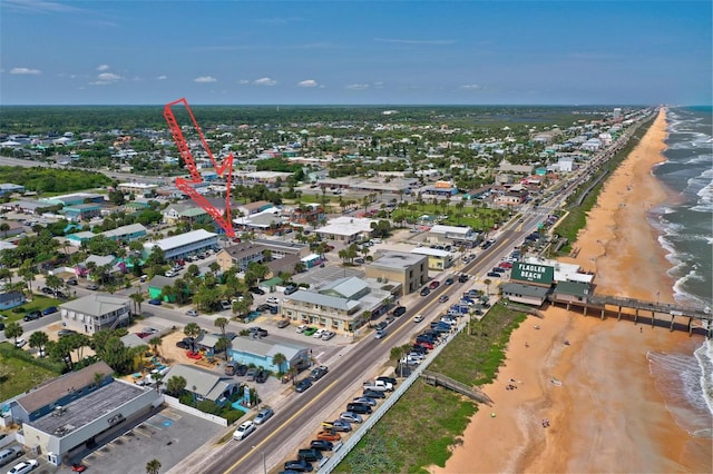 birds eye view of property with a water view and a beach view