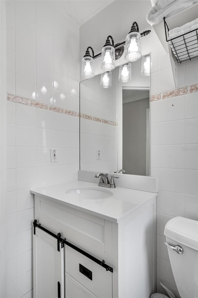 bathroom featuring tile walls, vanity, and toilet