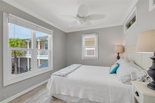 bedroom with crown molding, ceiling fan, and light hardwood / wood-style flooring