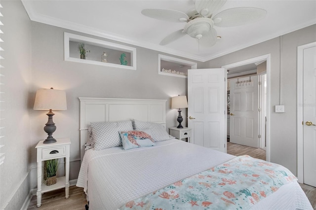 bedroom featuring ceiling fan, ornamental molding, and light hardwood / wood-style flooring