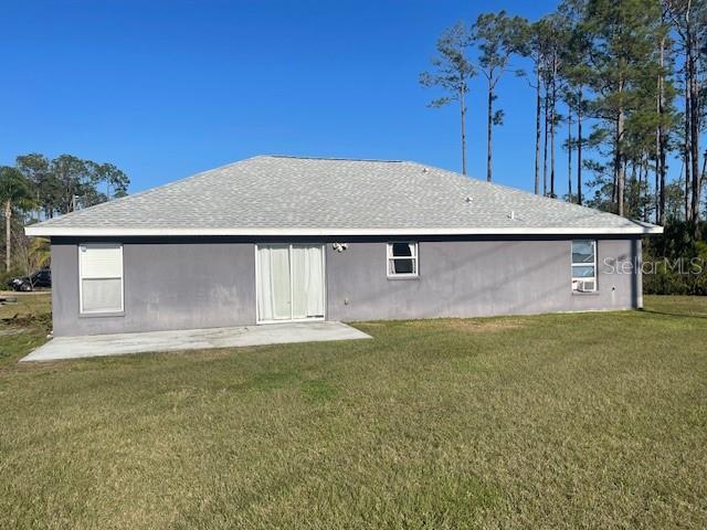 rear view of property featuring a yard and a patio area