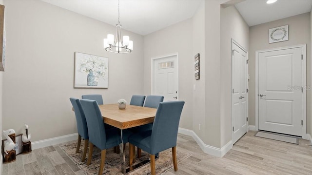 dining area with a chandelier and light hardwood / wood-style flooring