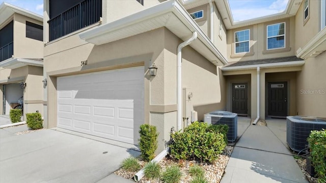 doorway to property featuring a garage and central air condition unit