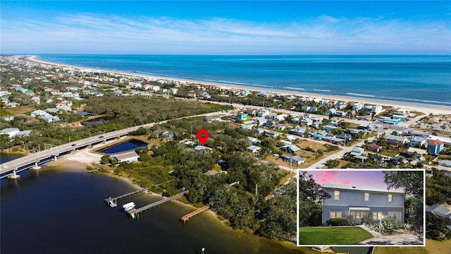 birds eye view of property with a water view and a beach view