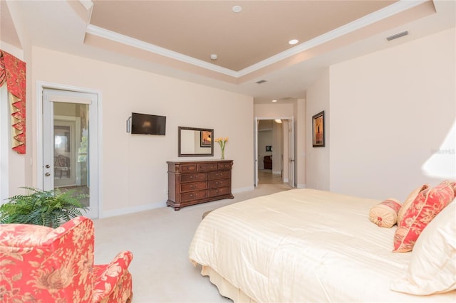 bedroom with crown molding, light colored carpet, and a tray ceiling