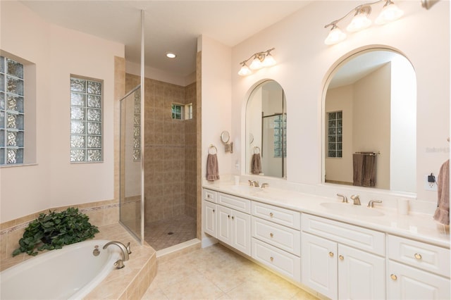 bathroom featuring tile patterned flooring, vanity, and plus walk in shower