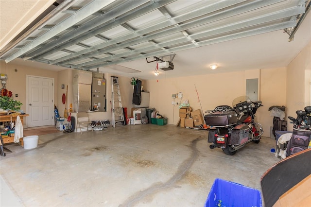 garage with a garage door opener, heating unit, and electric panel