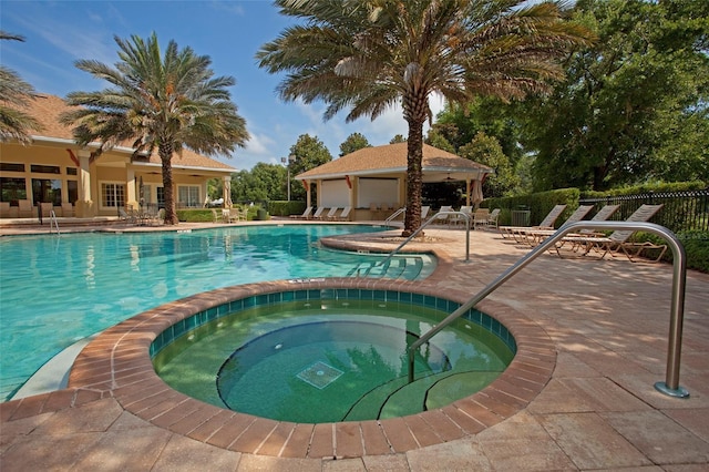 view of swimming pool featuring a patio and a community hot tub