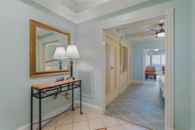 hallway featuring light tile patterned floors and beamed ceiling