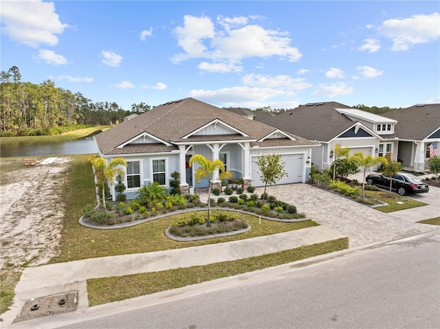 view of front of home with a garage and a water view