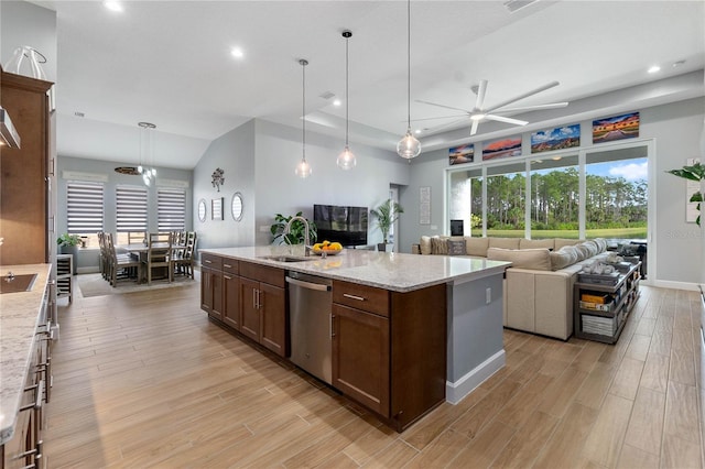 kitchen featuring sink, decorative light fixtures, stainless steel dishwasher, light stone countertops, and light hardwood / wood-style floors