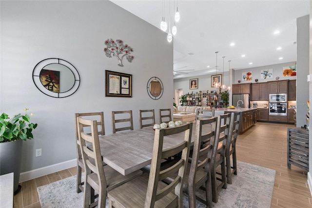 dining space with ceiling fan and light wood-type flooring