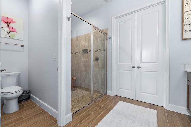 bathroom with a shower with shower door and toilet