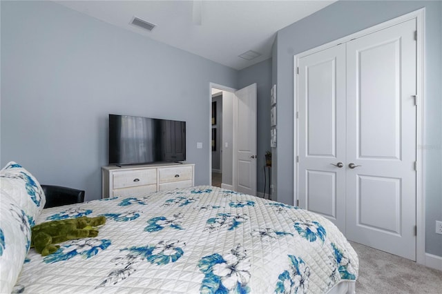 bedroom featuring light carpet, ceiling fan, and a closet