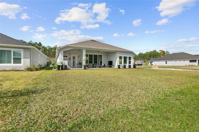 rear view of house featuring a lawn and a patio