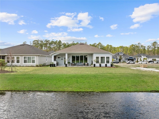 rear view of property with central AC, a lawn, and a water view