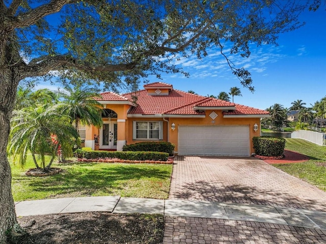 mediterranean / spanish-style house with a garage and a front yard