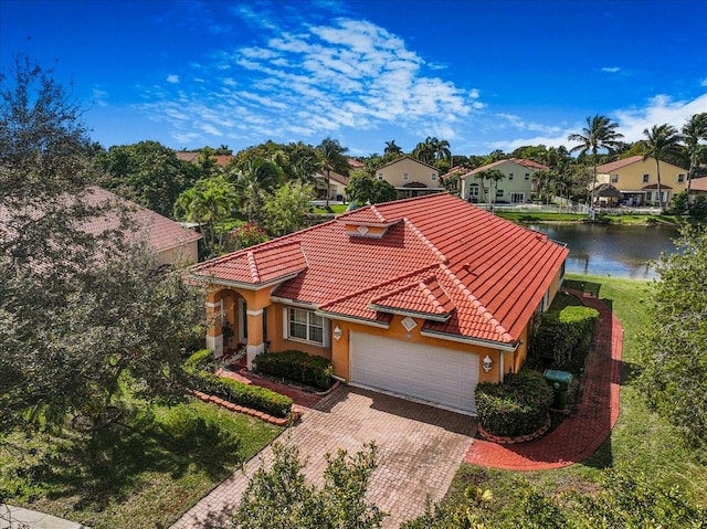 mediterranean / spanish house with a garage and a water view