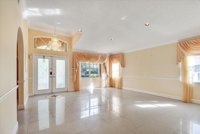 foyer entrance with light tile patterned floors, crown molding, and a textured ceiling