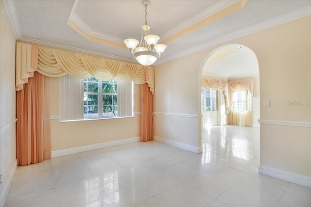 tiled empty room with crown molding, a tray ceiling, a textured ceiling, and an inviting chandelier