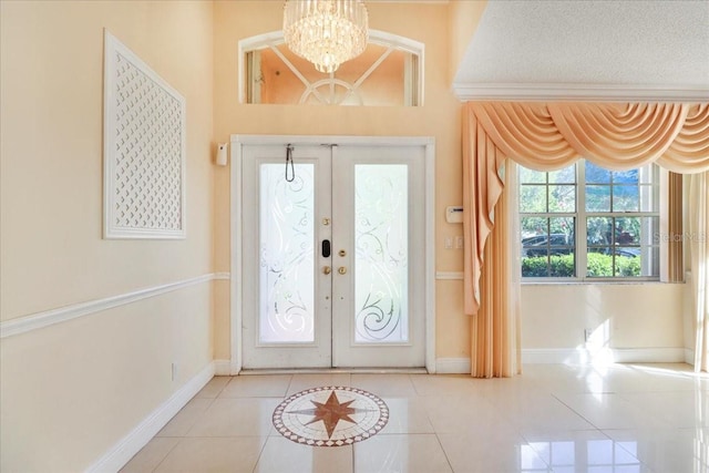 entrance foyer featuring french doors, an inviting chandelier, and light tile patterned floors