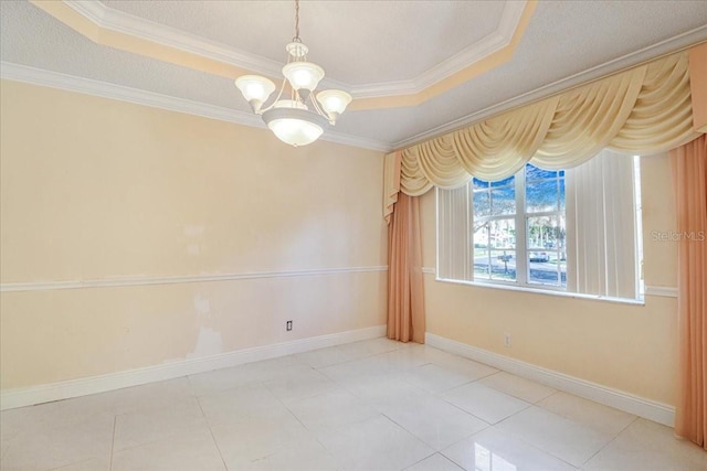 empty room featuring ornamental molding, a tray ceiling, tile patterned flooring, and a notable chandelier