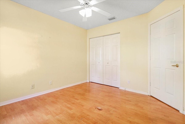 unfurnished bedroom featuring wood-type flooring, ceiling fan, and a closet