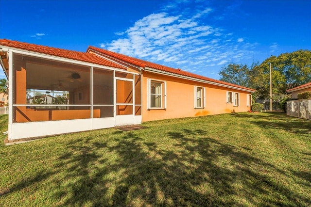 rear view of property with a yard and a sunroom