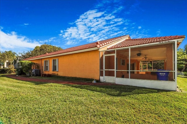 view of side of property featuring ceiling fan, a yard, and central air condition unit