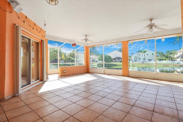 unfurnished sunroom with a water view and ceiling fan