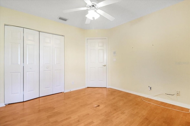 unfurnished bedroom featuring wood-type flooring, a closet, and ceiling fan