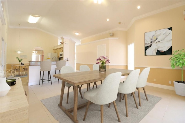 dining room featuring crown molding, lofted ceiling, and light tile patterned floors