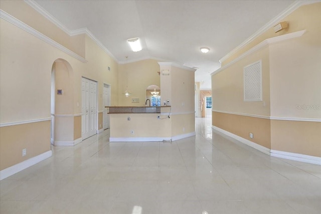 interior space featuring vaulted ceiling, ornamental molding, sink, and light tile patterned floors